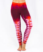 Woman wearing a pair of red tie dye leggings by Akasha Sun.