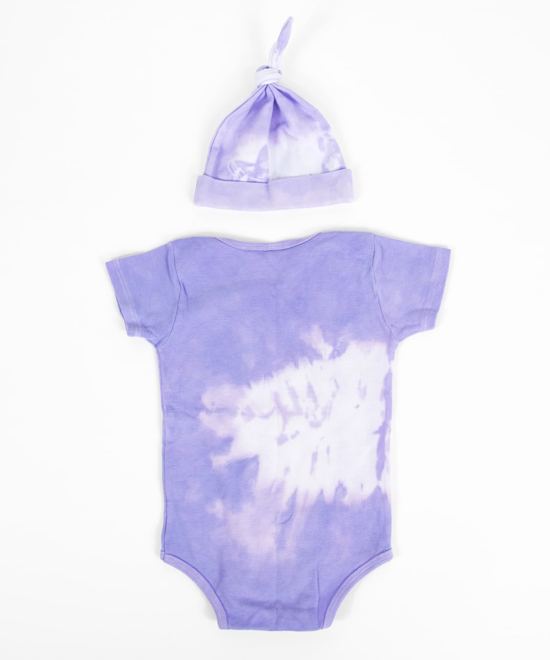 Purple and white tie dye baby set that includes an organic onesie, organic baby hat, and jacket.