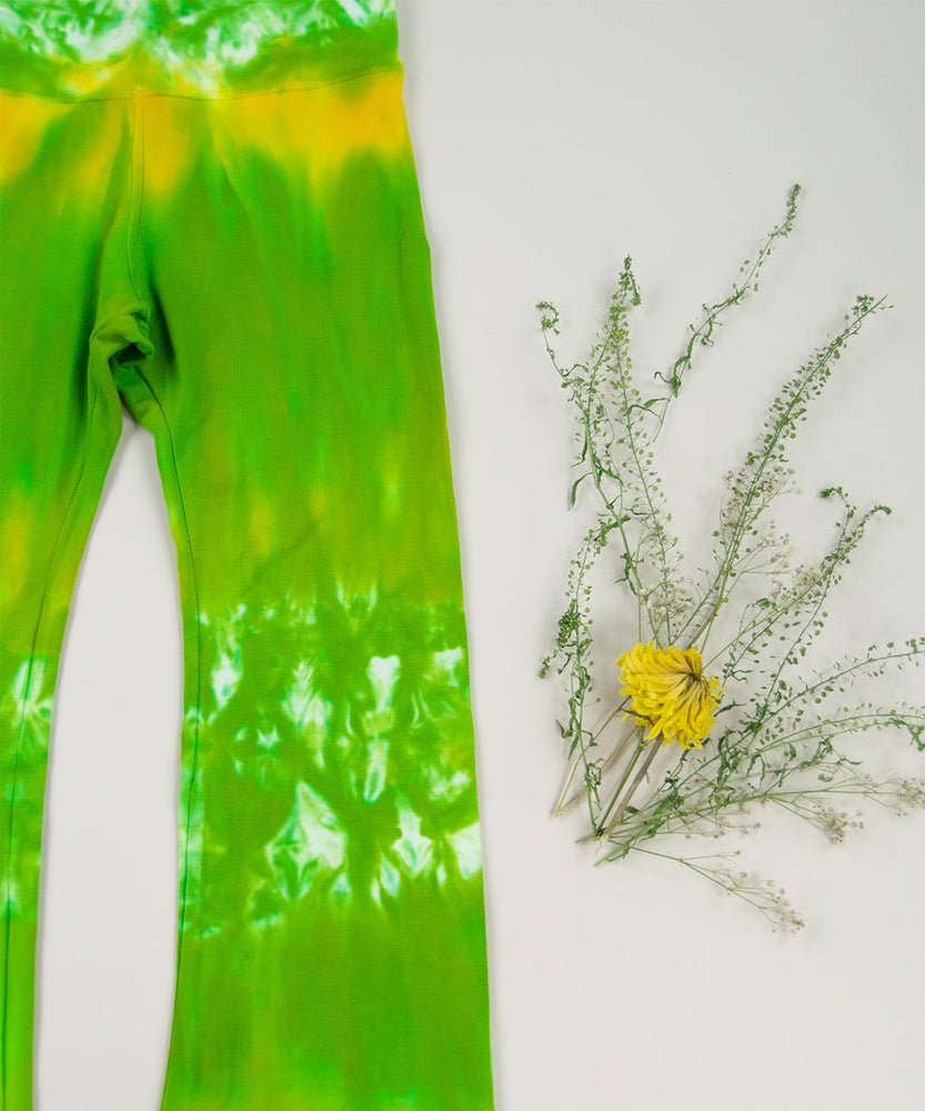 Yellow and green tie dye yoga pants with a wide waistband and flare bottoms by Akasha Sun.