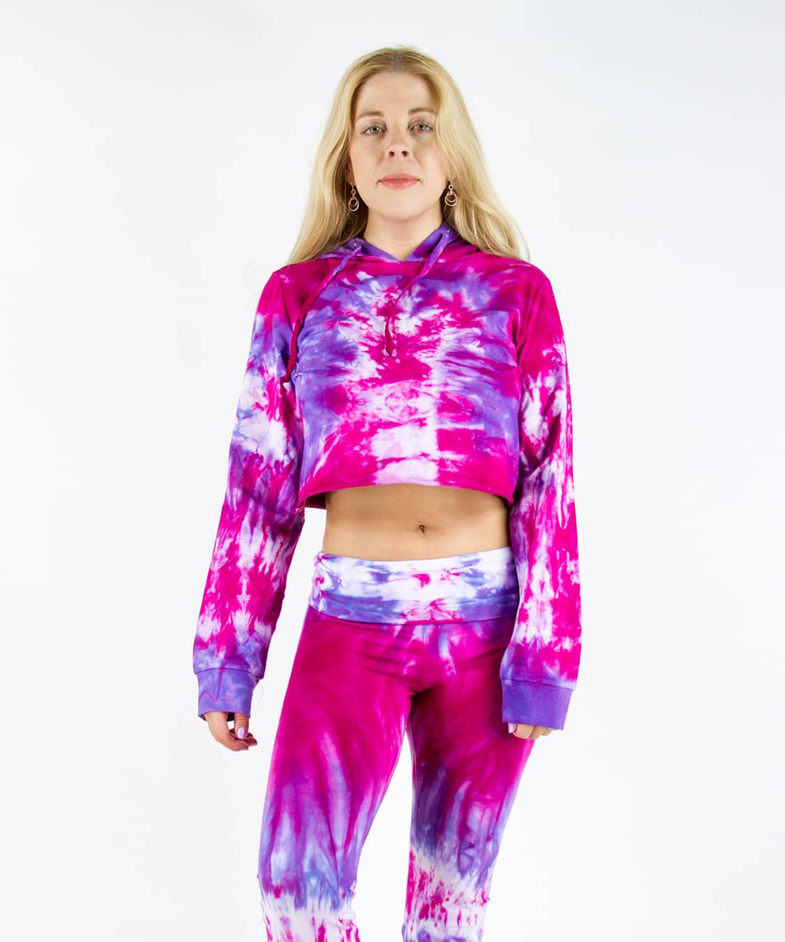 Woman wearing a pink and purple tie dye hoodie crop top.