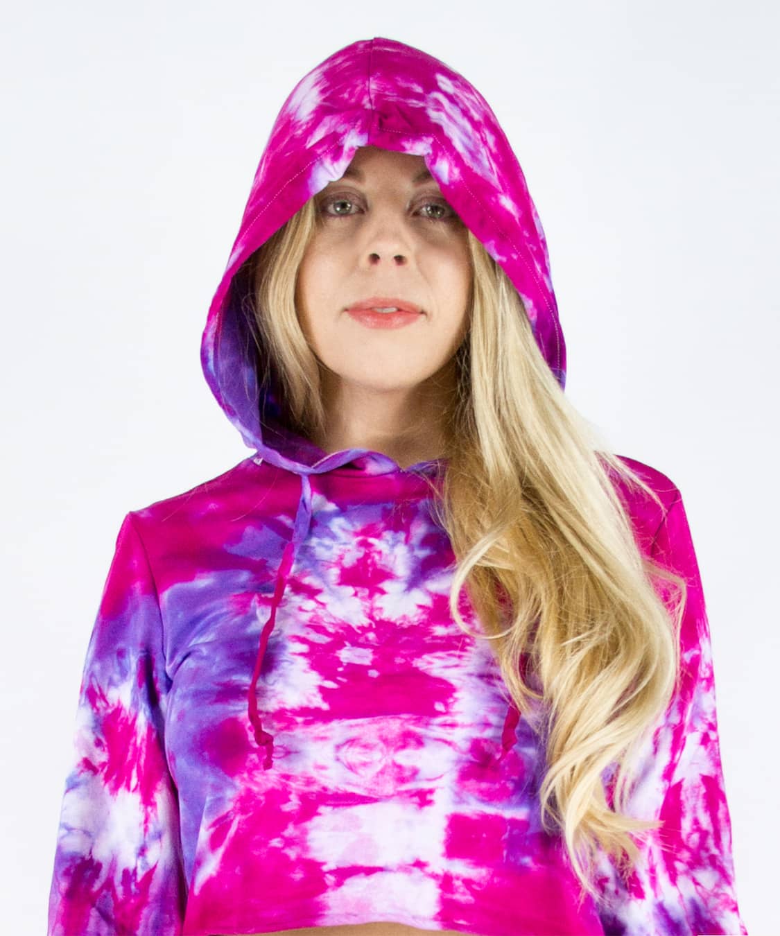 Woman wearing a pink and purple tie dye hoodie crop top.