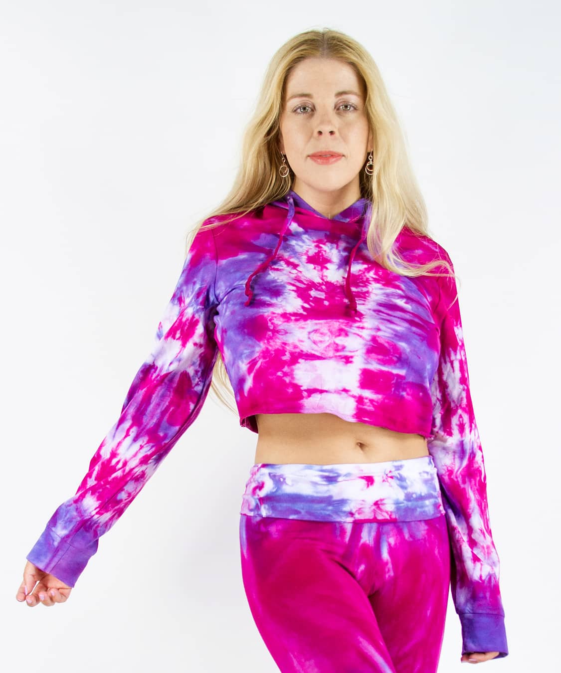 Woman wearing a pink and purple tie dye hoodie crop top.