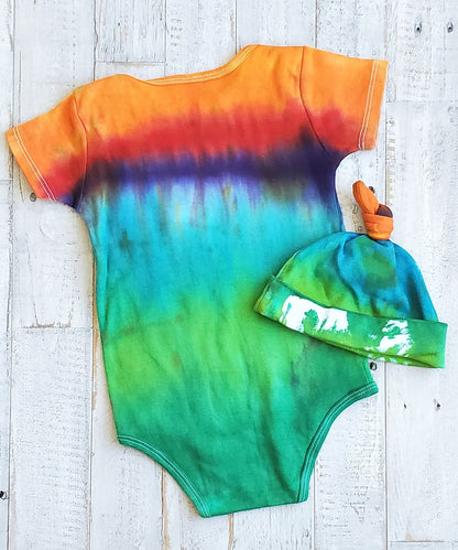 An organic tie dye baby bodysuit and hat in rainbow colors.An organic tie dye baby bodysuit and hat in rainbow colors.