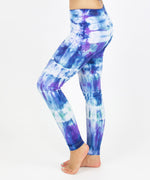 Woman wearing the Mykonos tie dye leggings with the color blue, purple, light teal, and white.