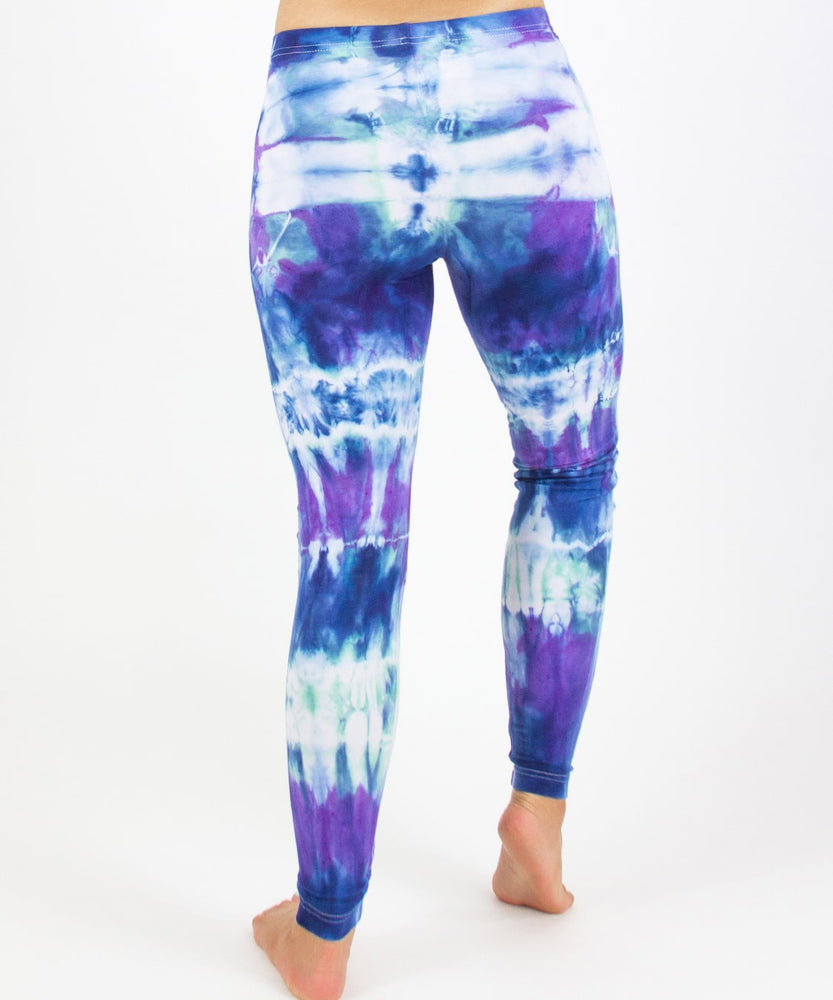 
                
                    Load image into Gallery viewer, Woman wearing the Mykonos tie dye leggings with the color blue, purple, light teal, and white.
                
            