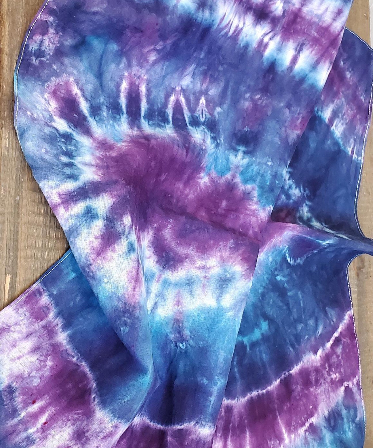 A dog modeling our tie dye bandana in blue and purple.