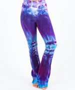 Woman wearing a pair of Akasha Sun tie dye yoga pants in blue and purple.