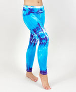 Woman wearing a pair of blue and purple tie dye fold over leggings.  Also can be considered as tie dye maternity leggings.