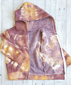 A rust tie dye children's jacket with fleece lining, pockets, and hood.