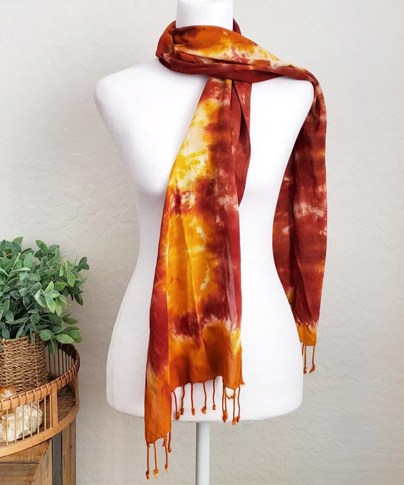 A rust orange tie dye scarf with fringe.