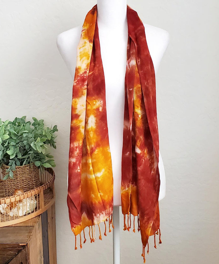 A rust orange tie dye scarf with fringe.