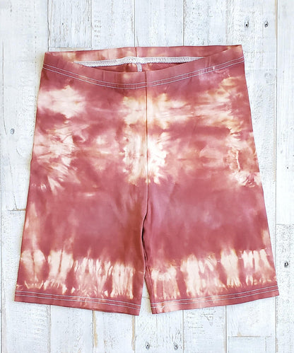 A pair of rust tie dye bike shorts.