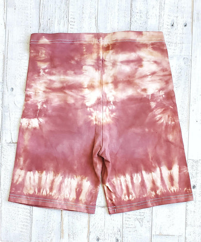 A pair of rust tie dye bike shorts.