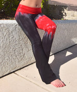 Woman wearing a pair of black and red chakra tie dye yoga pants.