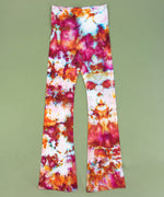 Pink and orange ice dye yoga pants with a wide waistband and flare bottoms.