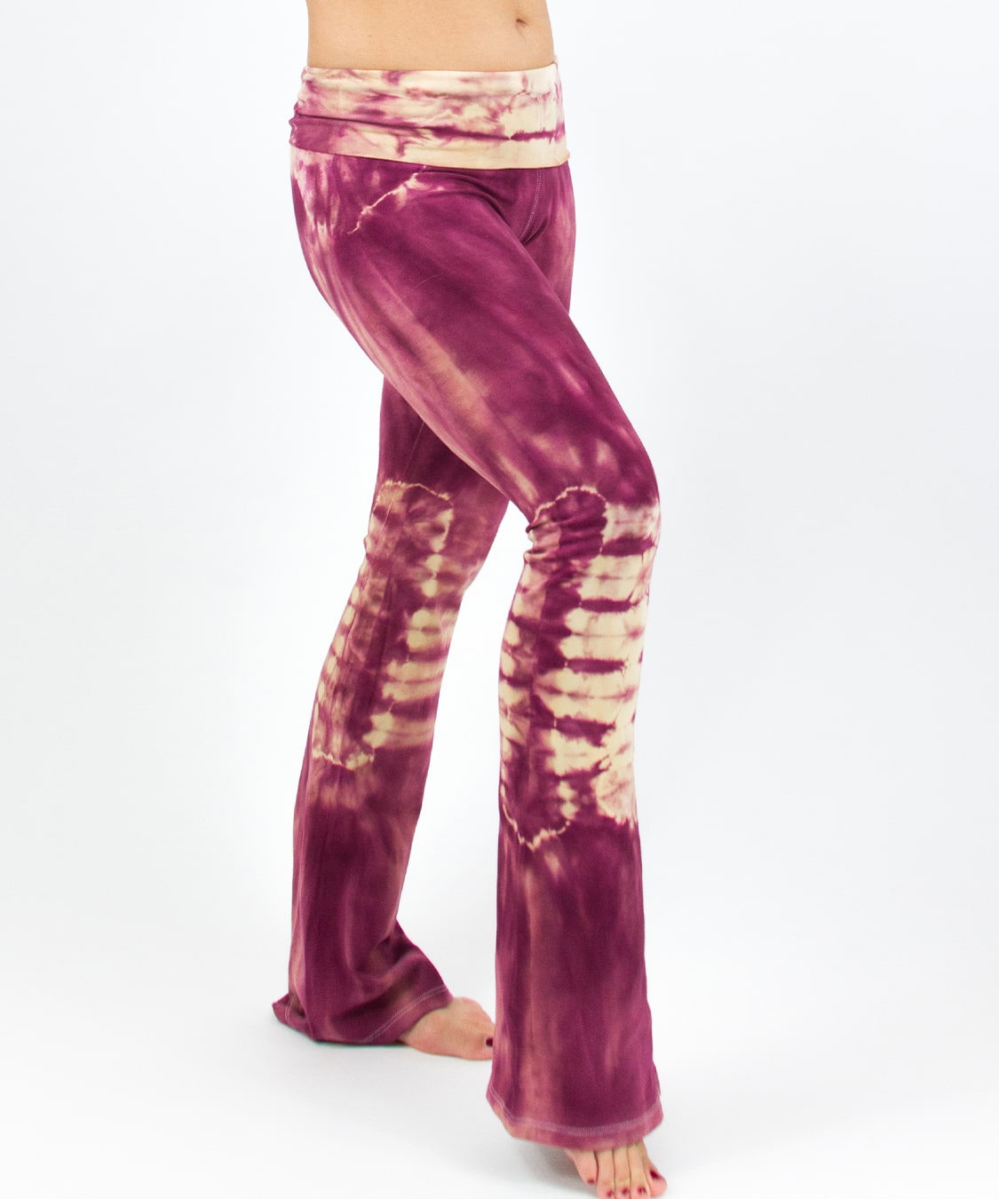 Woman wearing a pair of rose pink tie dye yoga pants with a fold over waistband by Akasha Sun.