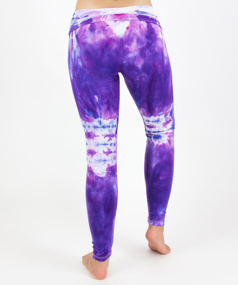 
                
                    Load image into Gallery viewer, Woman wearing the Saint-Tropez tie dye leggings that feature a fold over waistband.  The colors in these pants include purple, pink, and white.
                
            