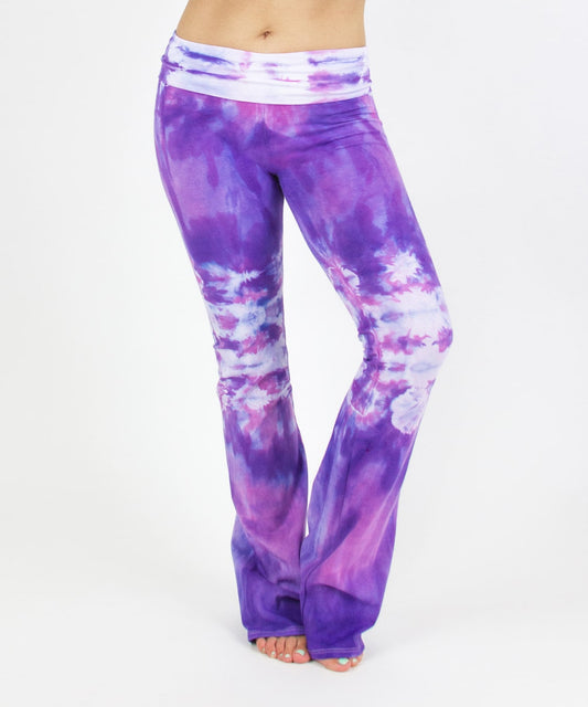 Woman wearing the Saint-Tropez tie dye yoga pants featuring the color purple, pink, and white.  The waistband can be folded down or up.