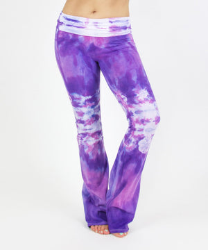 
                
                    Load image into Gallery viewer, Woman wearing the Saint-Tropez tie dye yoga pants featuring the color purple, pink, and white.  The waistband can be folded down or up.
                
            