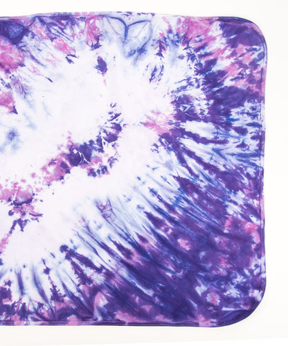 Pink and purple tie dye organic baby set that includes a baby blanket, onesie, and baby hat.