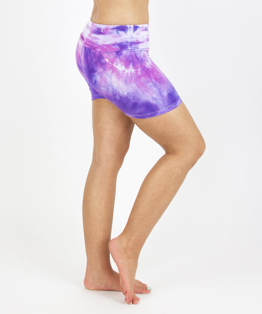 Woman wearing the Saint-Tropez fold over shorts that feature the color purple, pink, and white.