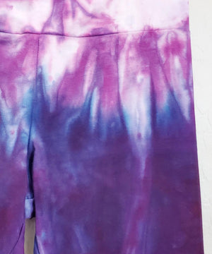 Purple and pink tie dye yoga pants with wide waistband.