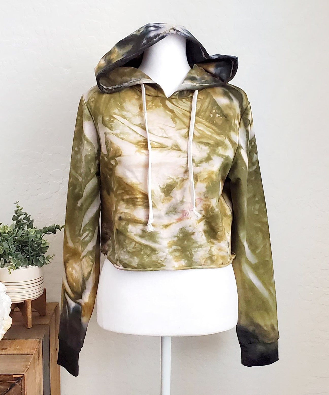 Green and black tie dye hoodie crop top with long sleeves.