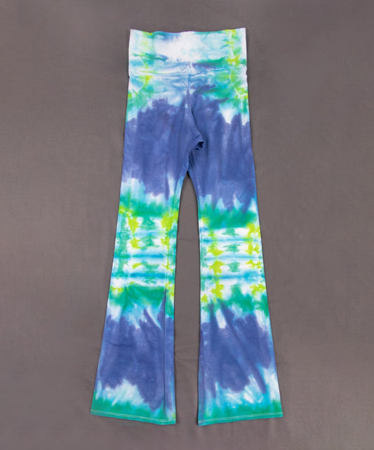 Teal, green, and blue tie dye yoga pants with a wide waistband and flare bottoms.