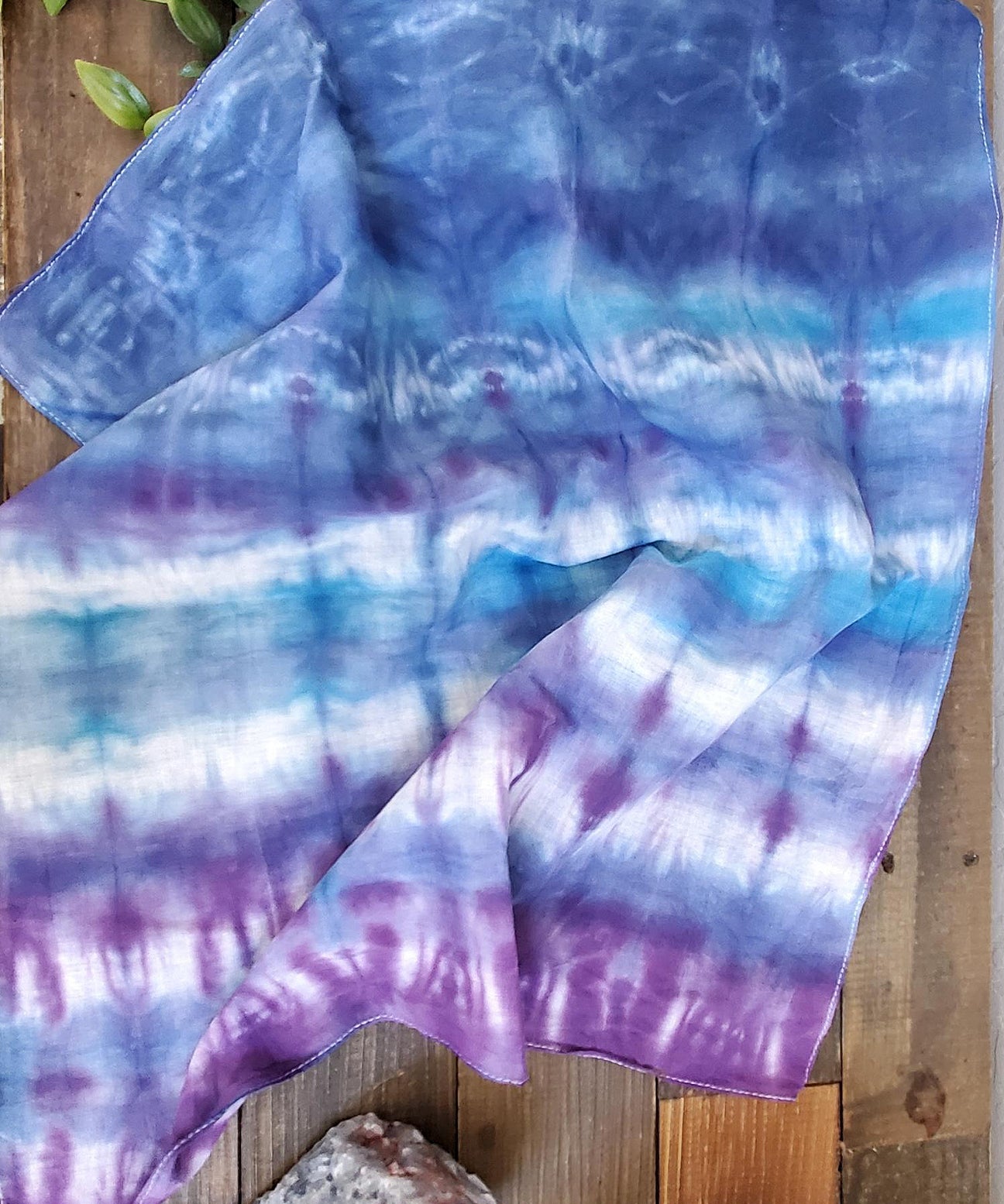 A dog modeling our tie dye bandana in blue and purple.