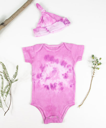 Organic cotton baby bodysuit and hat set in pink.