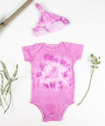 Organic cotton baby bodysuit and hat set in pink.
