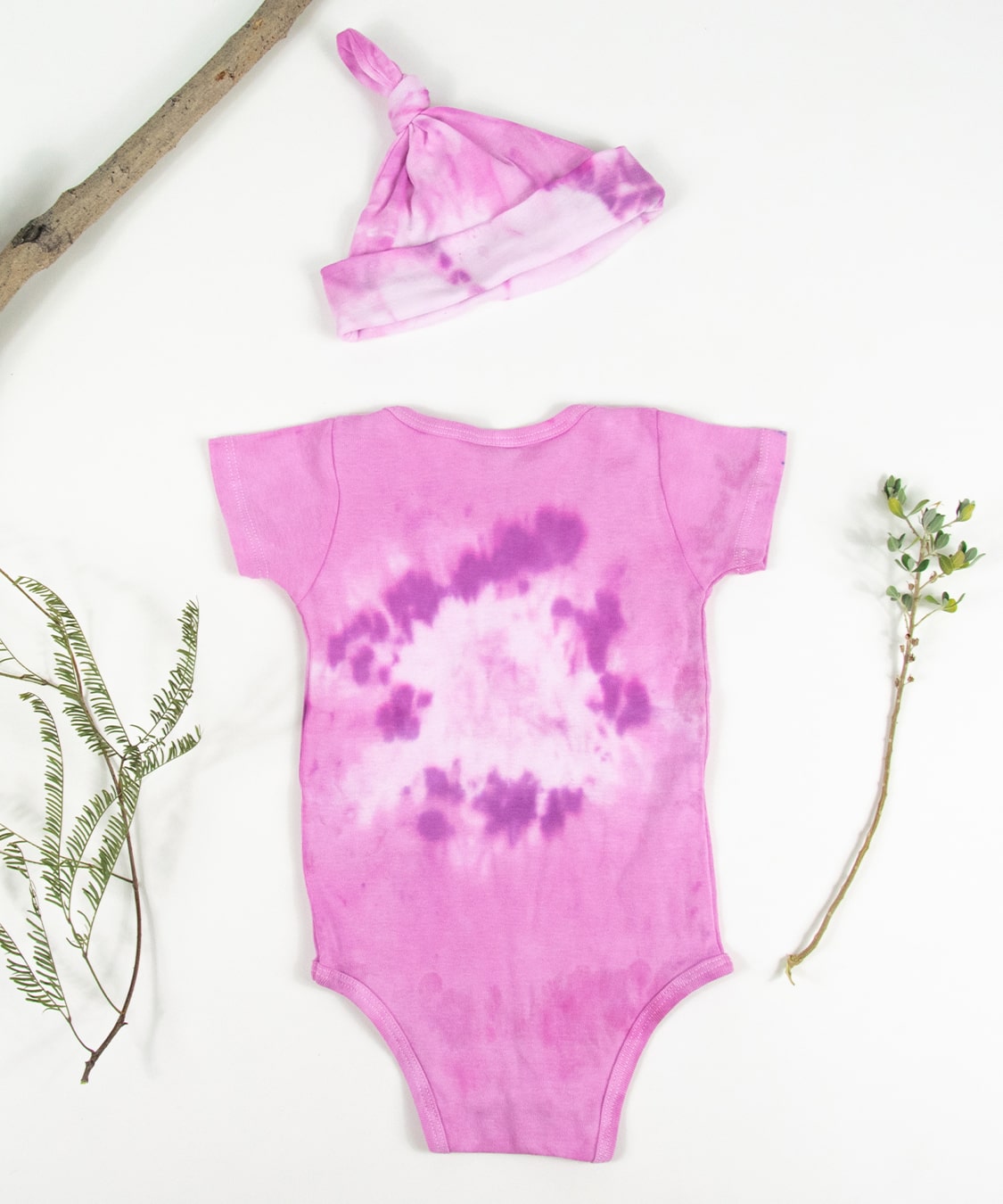 Organic cotton baby bodysuit and hat set in pink.